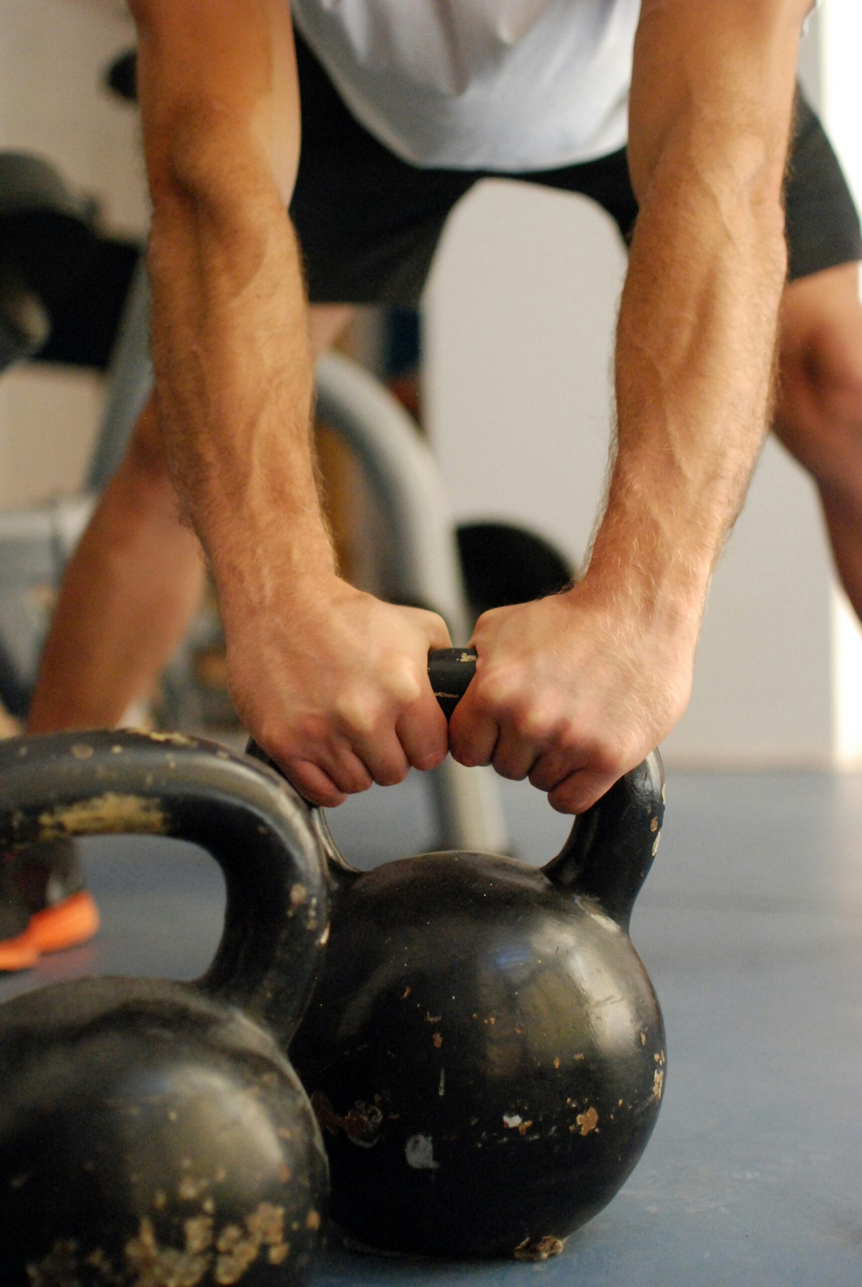 Two hands wrapped around a kettlebell handle