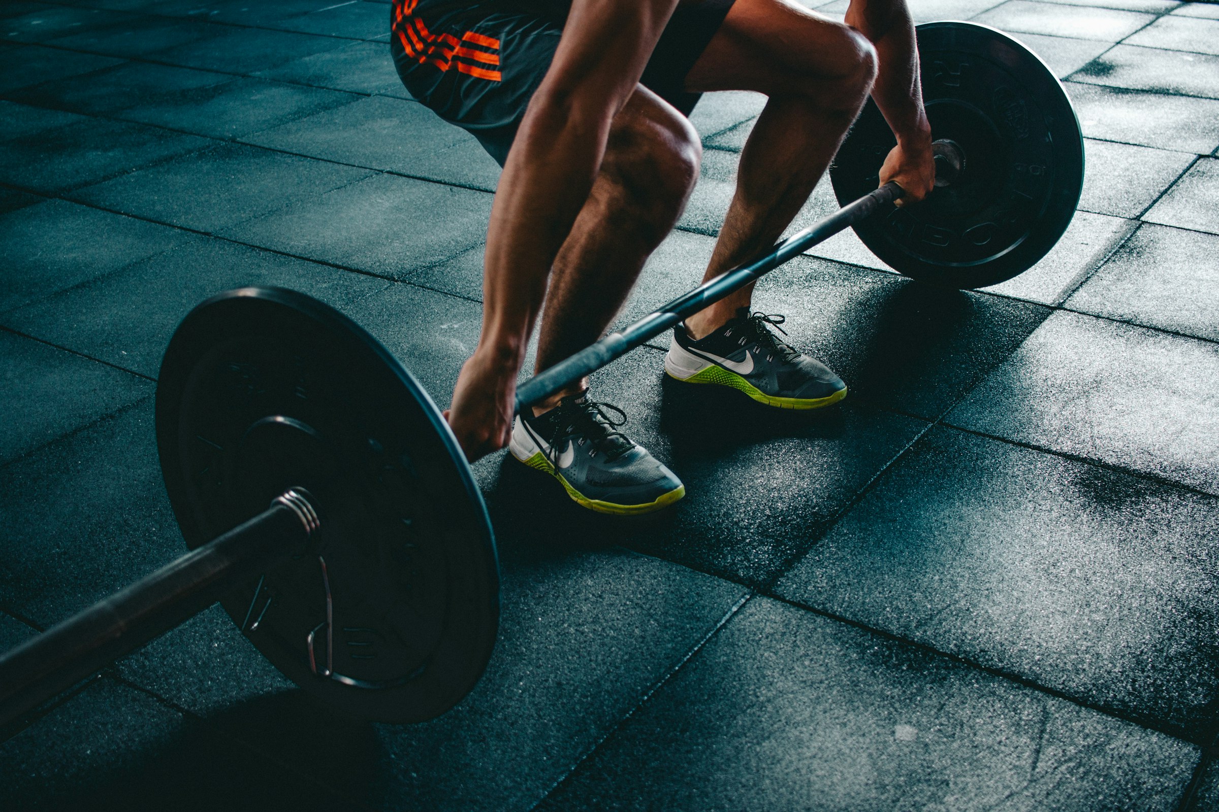 A lifter gripping a loaded barbell, ready to pull